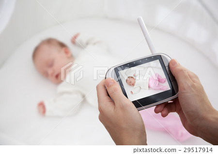 Hand holding video baby monitor for security of 29517914