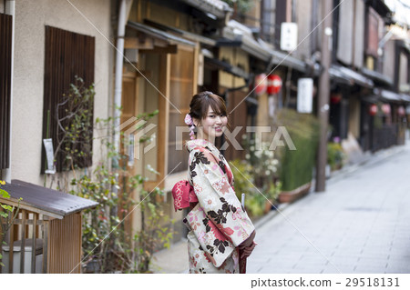 一个年轻的女子 在京都府京都市东山区的祗园hanami通道背景中的和服的微笑 图库照片