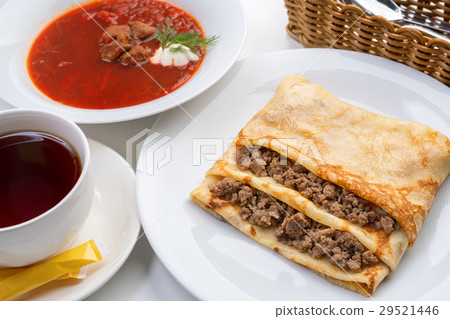 Pancake stuffed with meat and borsch with greenery 29521446