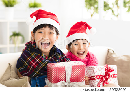 happy little girls showing christmas gift on  sofa 29528691