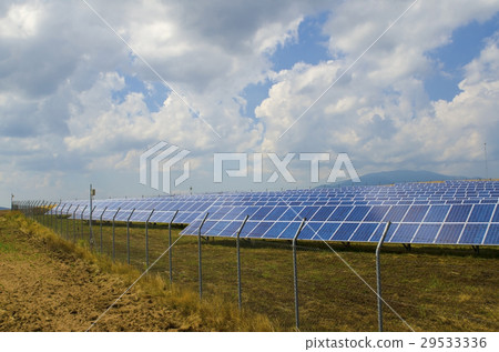 Lots of solar panels behind rusty barbed wire 29533336