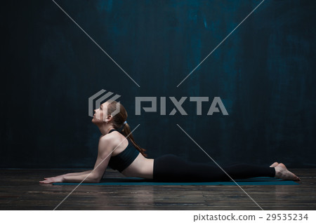 Side view of flexible woman doing yoga indoors 29535234
