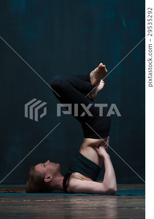 Beautiful girl practicing advanced yoga in class Beautiful girl practicing advanced yoga in class 29535292