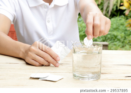 woman dropping effervescent tablet in water glass woman dropping effervescent tablet in water glass 29537895