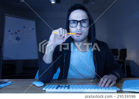 Handsome thoughtful hacker breaking into a website 29539396