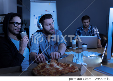 Pleasant positive programmer taking pizza slices 29539410