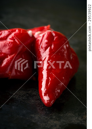 Three red chili peppers on dark tray 29539922