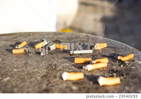 Cigarette in outdoors ashtray with sand closeup 29540293