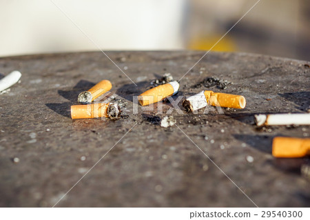 Cigarette in outdoors ashtray with sand closeup Cigarette in outdoors ashtray with sand closeup 29540300