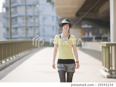 一個年輕的女人走在橋上 一個年輕的女人走在橋上 29543234