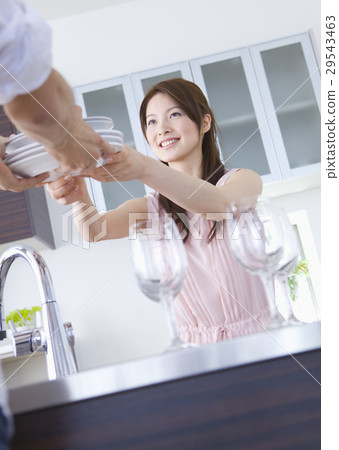 A young woman passing a dish 29543463