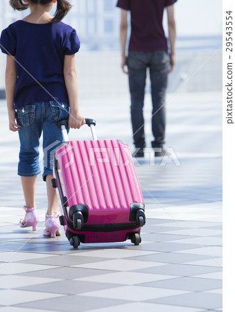A girl pulling a suitcase 29543554