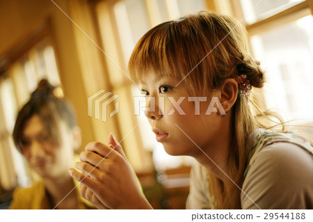 A woman relaxing at a cafe 29544188