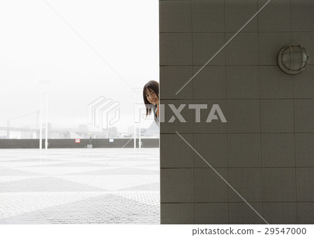 A woman hiding on the wall A woman hiding on the wall 29547000