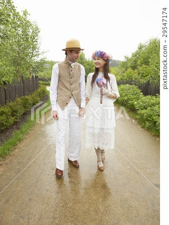 A bride and groom walking hand in hand A bride and groom walking hand in hand 29547174