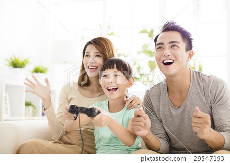 Laughing family playing video games in living room Laughing family playing video games in living room 29547193
