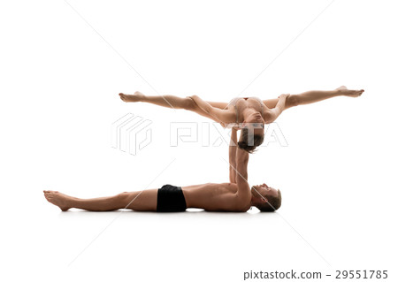 Male acrobat exercises with young girl in studio Male acrobat exercises with young girl in studio 29551785