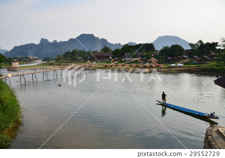 老撾班比森河和山和竹橋的景點一個男騎小船 29552729