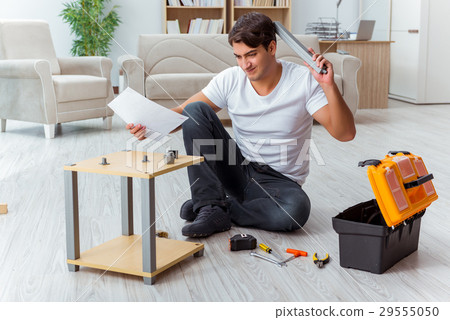 Man assembling furniture at home 29555050