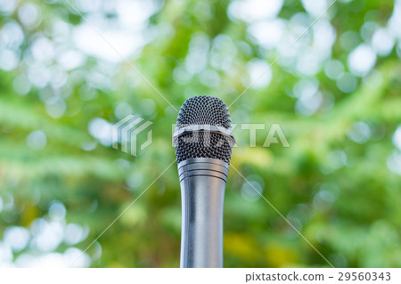 Black microphone in a park with defocused bokeh  29560343