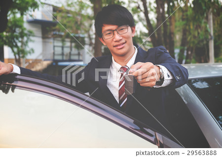 Cropped closeup of a car dealer holding out car ke Cropped closeup of a car dealer holding out car ke 29563888