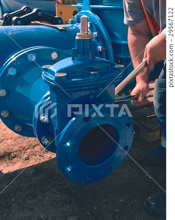 Worker screwing Gate valve with nuts on piping. Worker screwing Gate valve with nuts on piping. 29567122