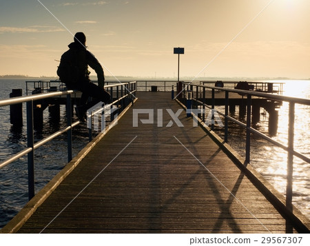Tourist sit on mole handrail and takes pictures. 29567307