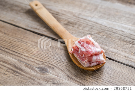 Bacon strips with pepper on wooden spoon 29568731