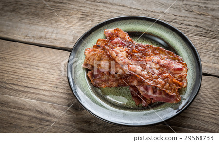 Stack of fried bacon strips on the plate Stack of fried bacon strips on the plate 29568733