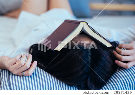 Female teen falls asleep while reading the book 29571429