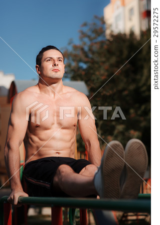 Young muscular build man doing pull ups exercises 29572275