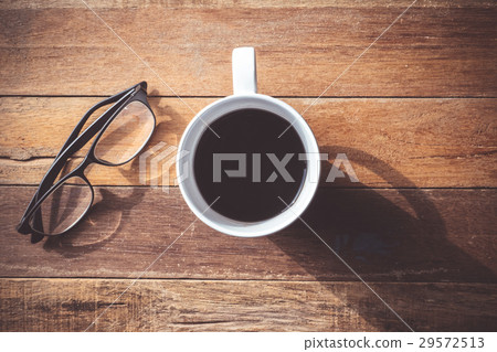 Coffee cup with Glasses on wooden table background Coffee cup with Glasses on wooden table background 29572513
