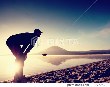 Man active exercising  and stretching at lake 29577520