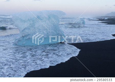 Ice breaking from glacier on black sand beach Ice breaking from glacier on black sand beach 29580533