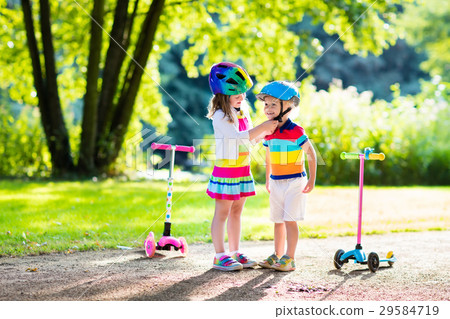 Kids riding scooter in summer park. 29584719