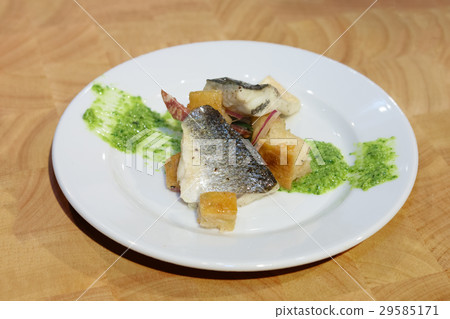 Tasty fish with crackers and green sauce on plate Tasty fish with crackers and green sauce on plate 29585171