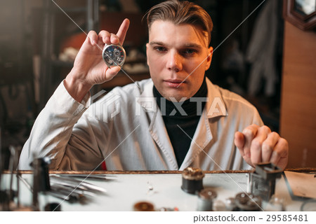 Watch maker holding wrist watch in hand 29585481