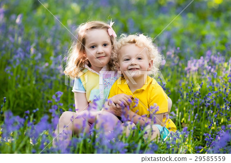 Kids in blooming garden with bluebell flowers 29585559