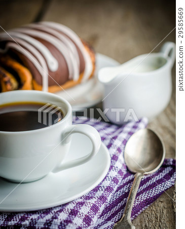 Cup of coffee and poppy bun glazed with ganache 29585669