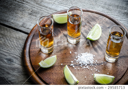 Glasses of tequila on the wooden board Glasses of tequila on the wooden board 29585713