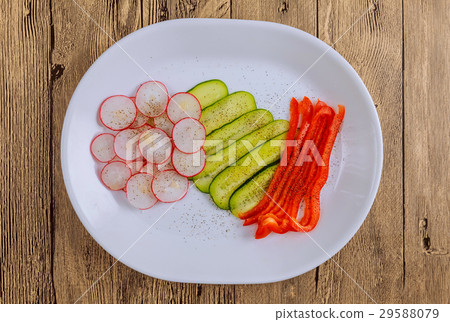 Fresh sliced vegetables lie on a plate on a wooden 29588079