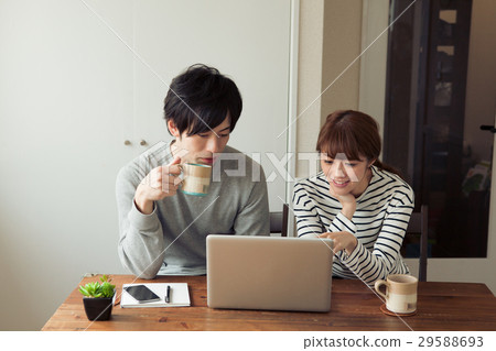 20's couple looking at laptop computers in the room 29588693