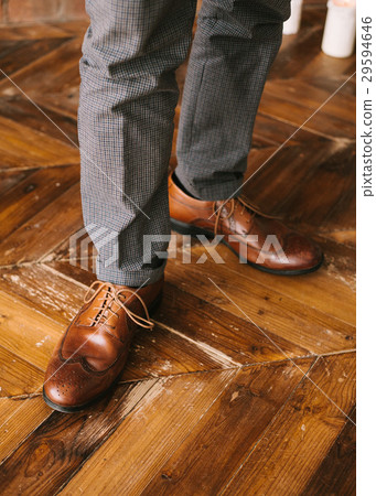 the man's legs in checkered trousers and brown 29594646