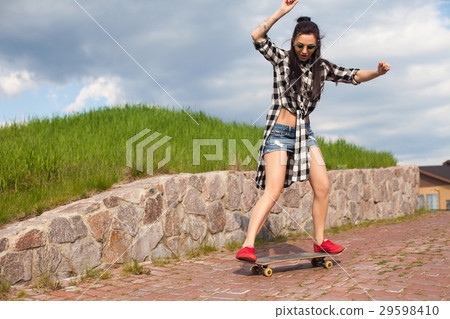 The woman does a trick with skate The woman does a trick with skate 29598410