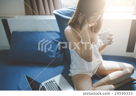 Woman drinking water on the bed Woman drinking water on the bed 29599333