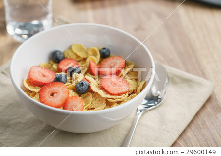 dry corn flakes with berries in bowl on table dry corn flakes with berries in bowl on table 29600149