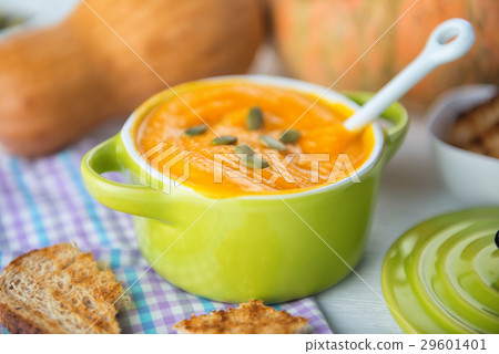 closeup of creamy pumpkin soup topped with pumpkin 29601401