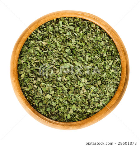Dried and grated lovage leaves in wooden bowl 29601878