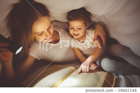 Mother and child read book under blanket with a flashlight. 29602148