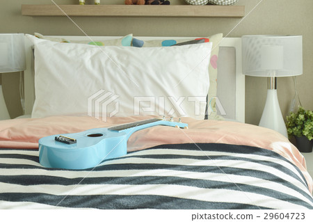 Light blue ukulele on striped bedding Light blue ukulele on striped bedding 29604723
